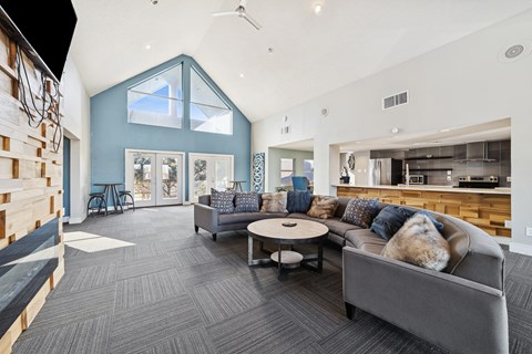A modern living room with a grey couch and a round coffee table.