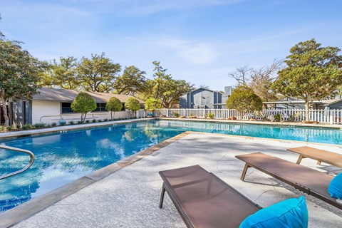 A pool with a bench and a table in front of it.