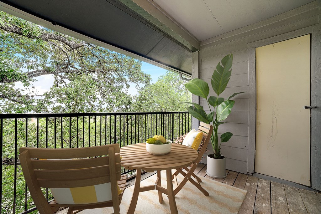 a patio with a table and chairs on a balcony at The Frederick, San Antonio, 78240