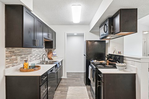 A kitchen with black cabinets and a white counter top.