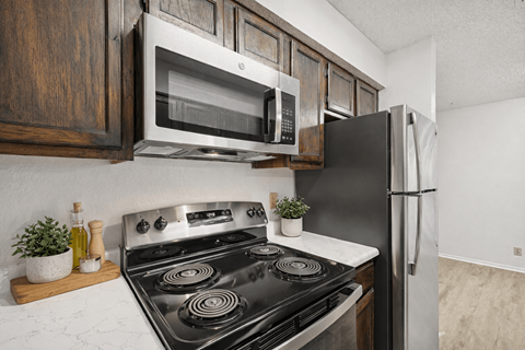 A kitchen with a black stove top oven and a black refrigerator.