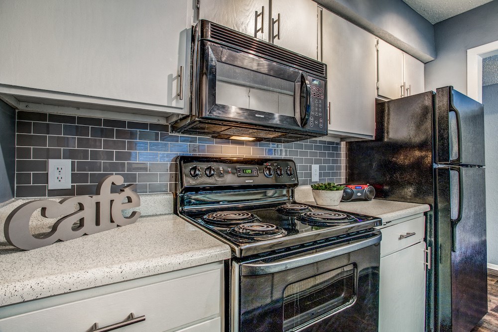 a kitchen with white cabinets and stainless steel appliances