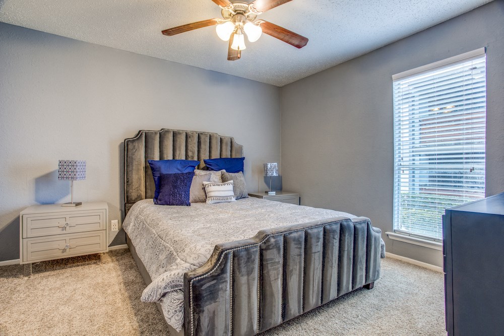 a bedroom with a bed and a ceiling fan