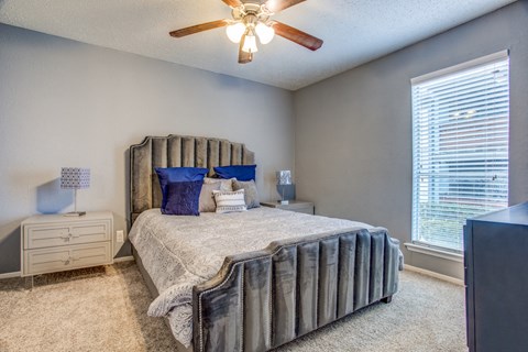 a bedroom with a bed and a ceiling fan