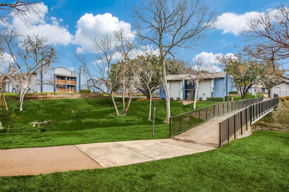a sidewalk leading to a house in a park