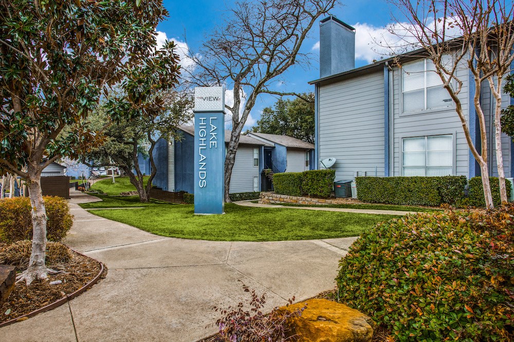 a sidewalk with a blue welcome sign in front of a house