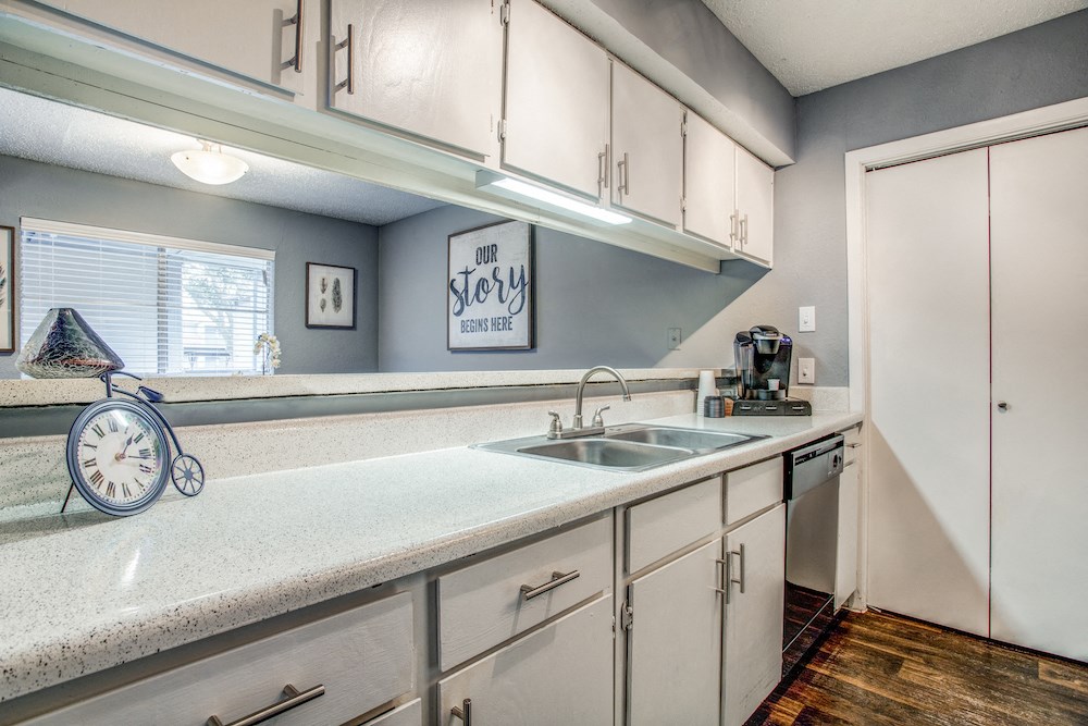 a kitchen with white cabinets and a white counter top