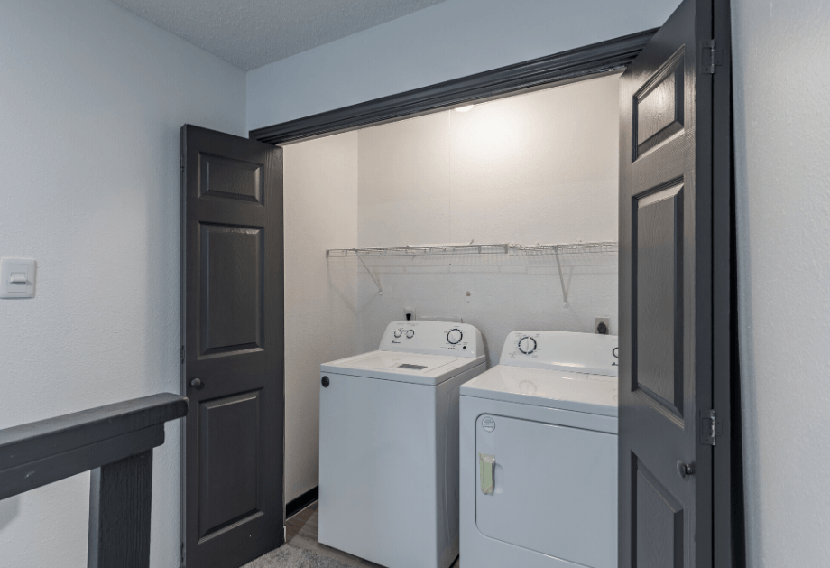 a laundry room with two washing machines and a door to a closet  at Tradewinds, Windcrest, TX, 78239