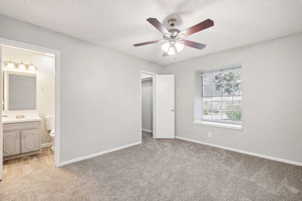 a bedroom with a ceiling fan and a window