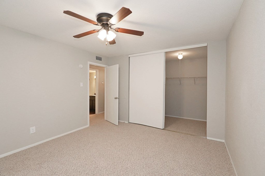 a bedroom with a ceiling fan and closet