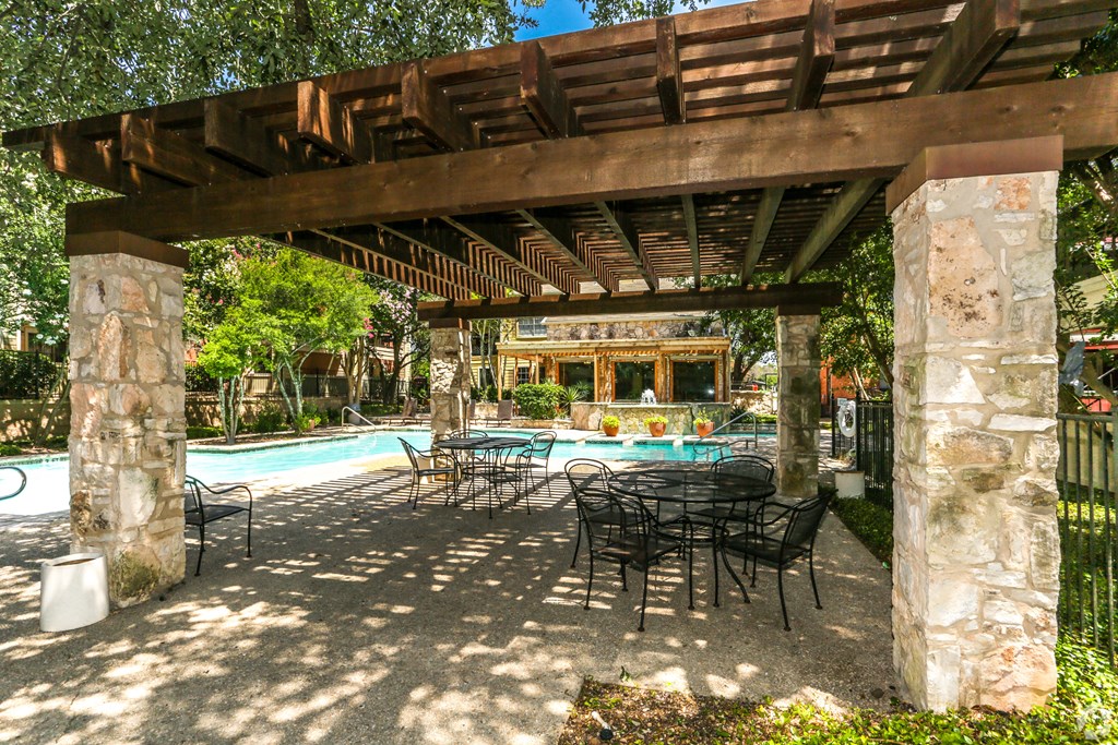 A patio with a table and chairs is shaded by a pergola.at Alamo Park, San Antonio, TX 78218