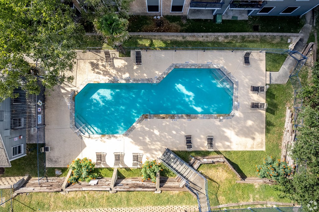 a house with a swimming pool in the middle of a grassy area at The Frederick, San Antonio, TX 78240