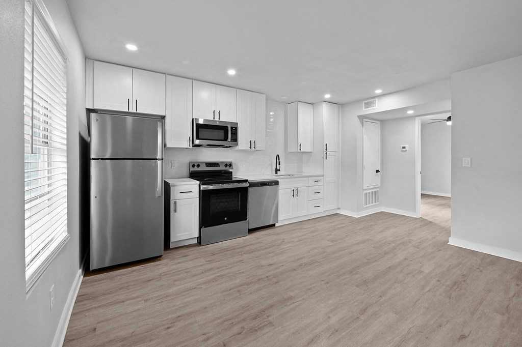 an empty kitchen with white cabinets and stainless steel appliances at Sunset Heights, Texas
