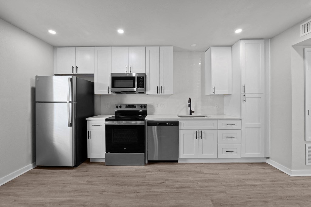 a white kitchen with stainless steel appliances and white cabinets at Sunset Heights, San Antonio, 78209