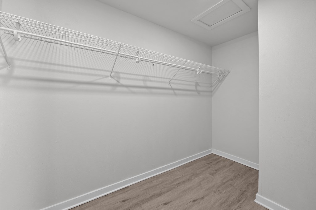 an empty bedroom with white walls and a white closet with a white rack on top at Sunset Heights, Texas, 78209