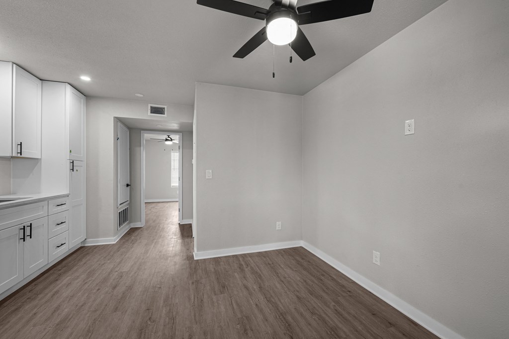 an empty living room with white walls and a ceiling fan  at Sunset Heights, San Antonio