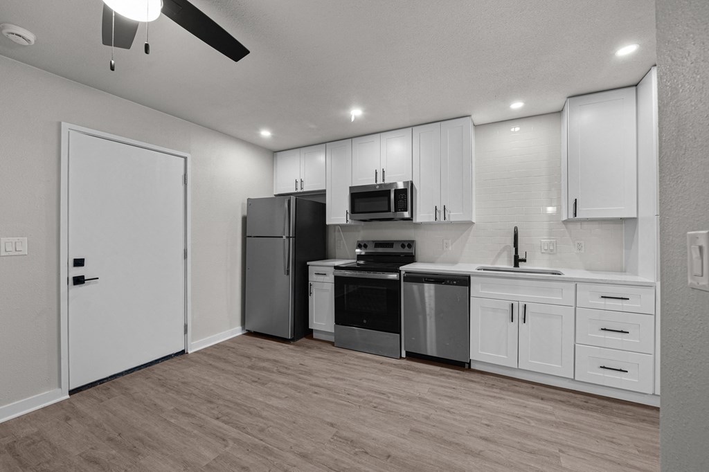 an empty kitchen with white cabinets and stainless steel appliances at Sunset Heights, Texas, 78209