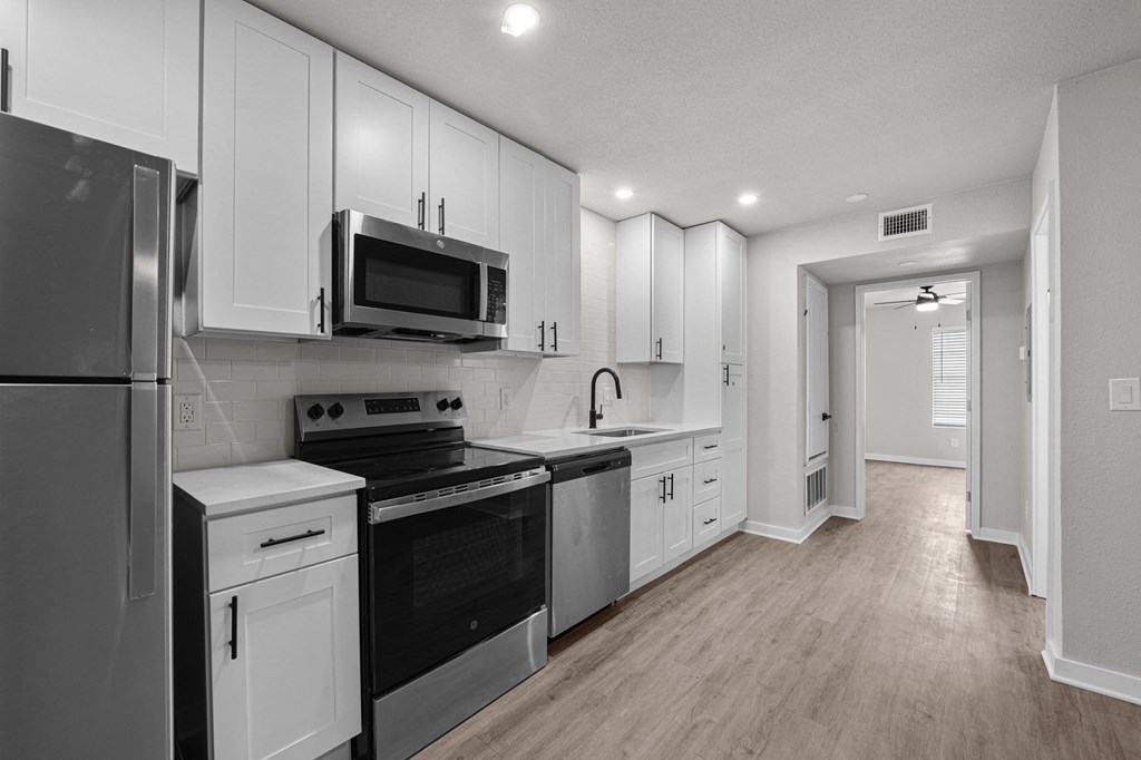 Photo of newly renovated kitchen with stainless steel appliances and white cabinetry at Sunset Heights, San Antonio, 78209