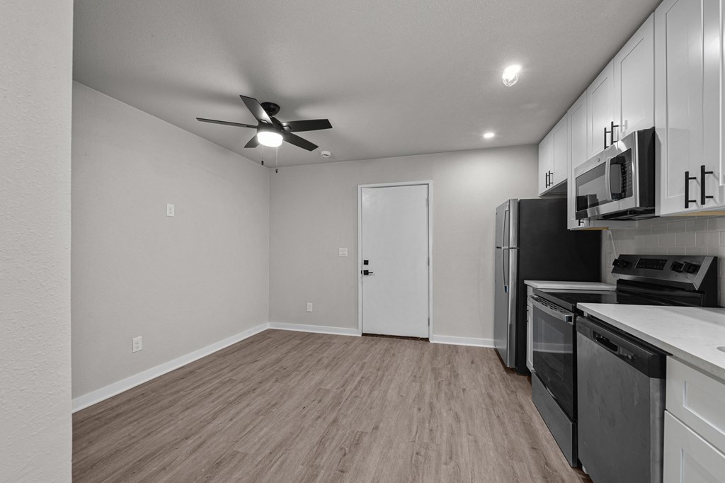 the living room of a home with a kitchen and a ceiling fan at Sunset Heights, San Antonio, TX, 78209