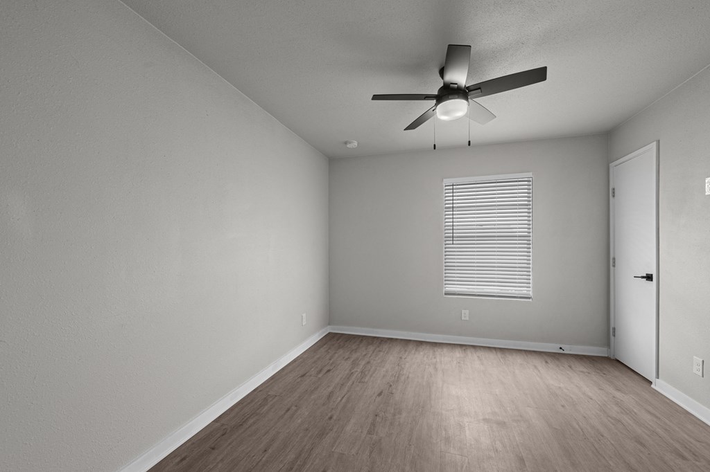 an empty living room with a ceiling fan and a door at Sunset Heights, San Antonio, TX