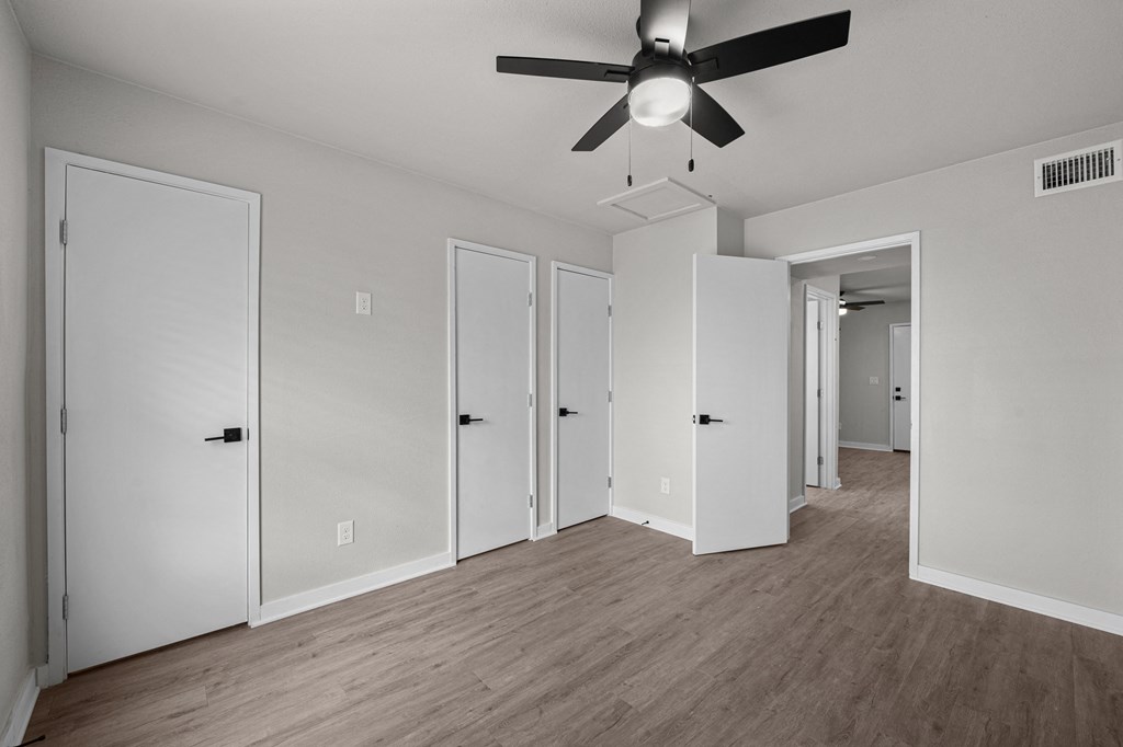 an empty living room with white walls and a ceiling fan at Sunset Heights, Texas