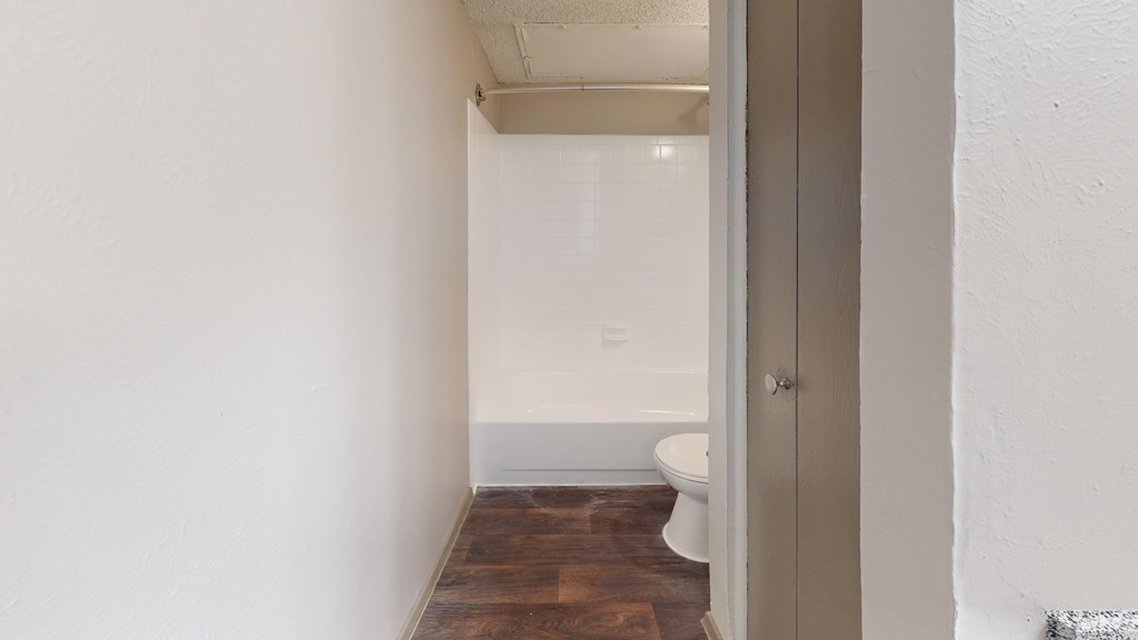 A white toilet sits in a small bathroom.