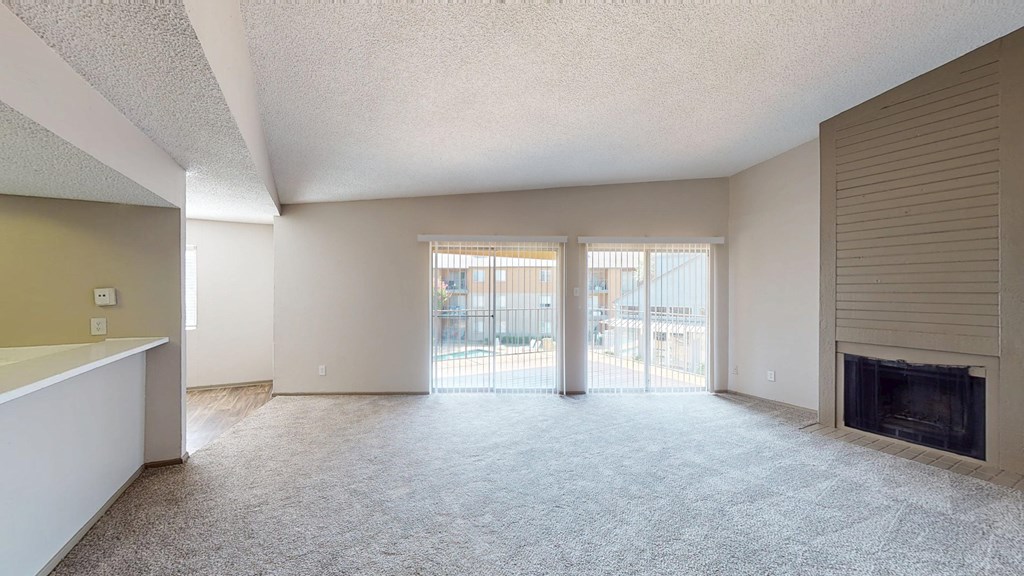 A spacious living room with a fireplace and sliding glass doors.