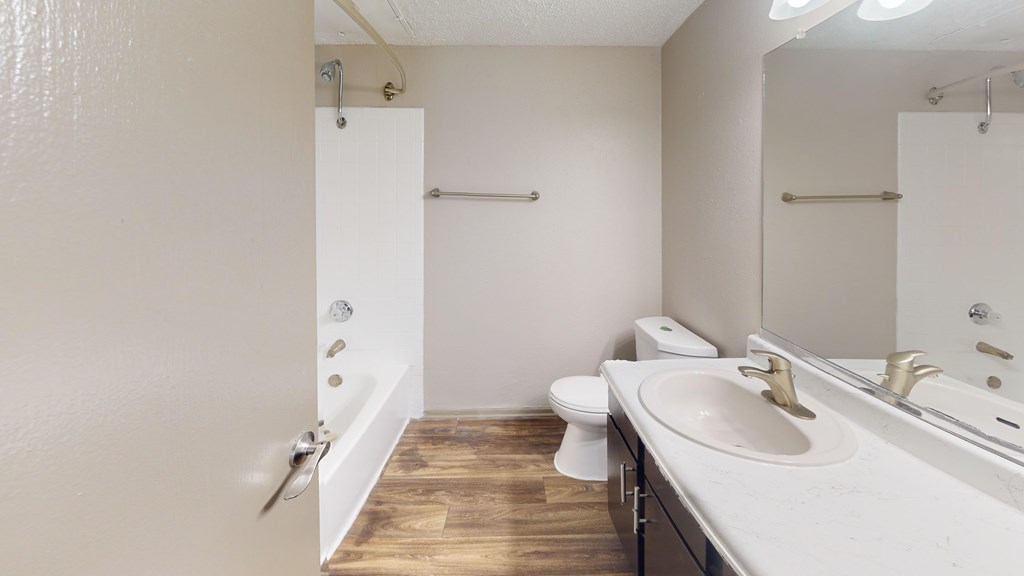 A bathroom with a white sink, toilet, and a white door.
