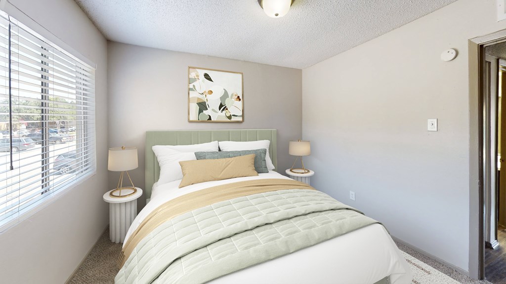 A bedroom with a large bed and a painting on the wall.