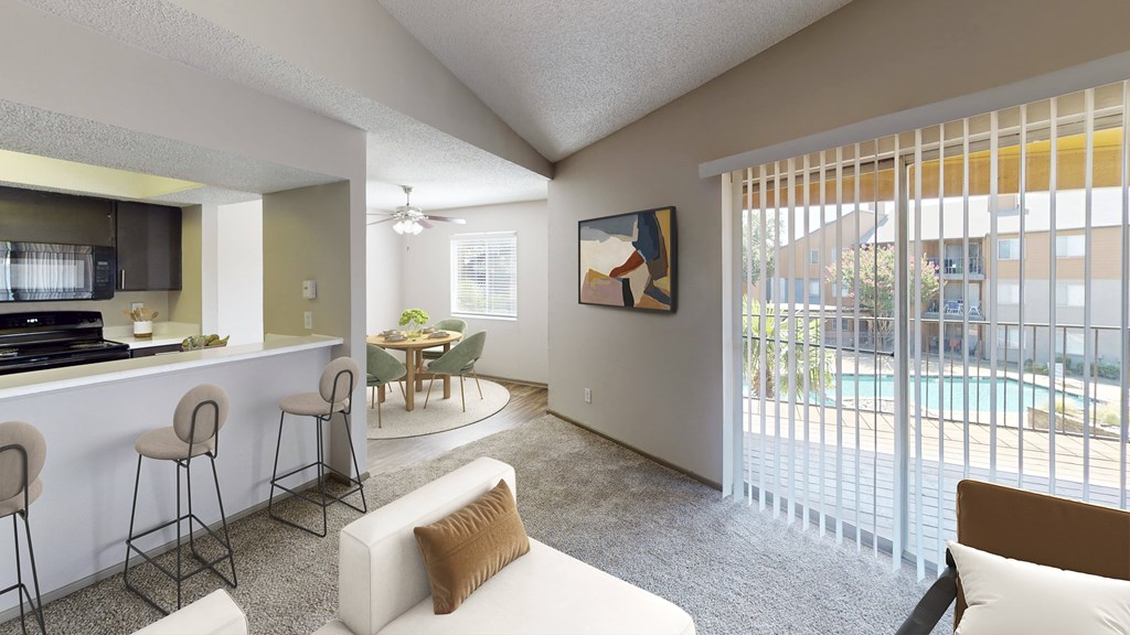 A living room with a bar area and a painting on the wall.