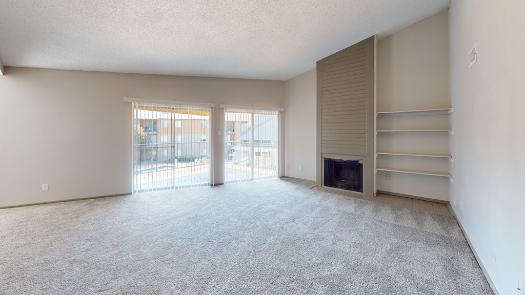 A spacious living room with a fireplace and sliding glass doors.