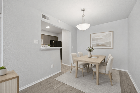 A dining room with a wooden table and chairs.