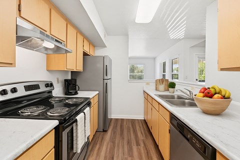A kitchen with wooden cabinets and a black stove top oven.
