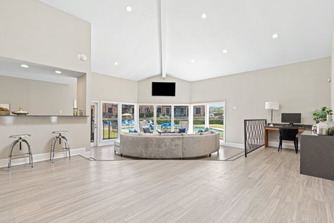 A spacious room with a television, a desk, and a large window overlooking a pool.