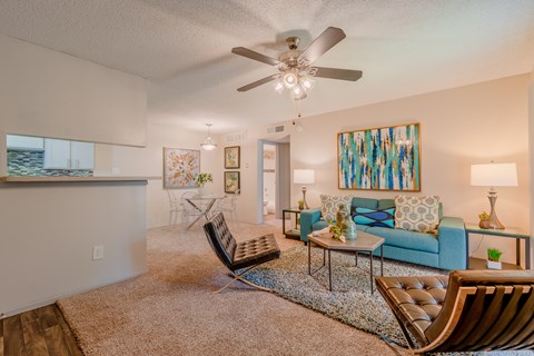 A living room with a blue couch and a ceiling fan.