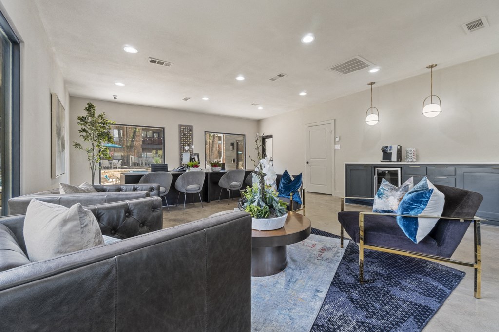 an open living room with couches and chairs and a dining room with a table