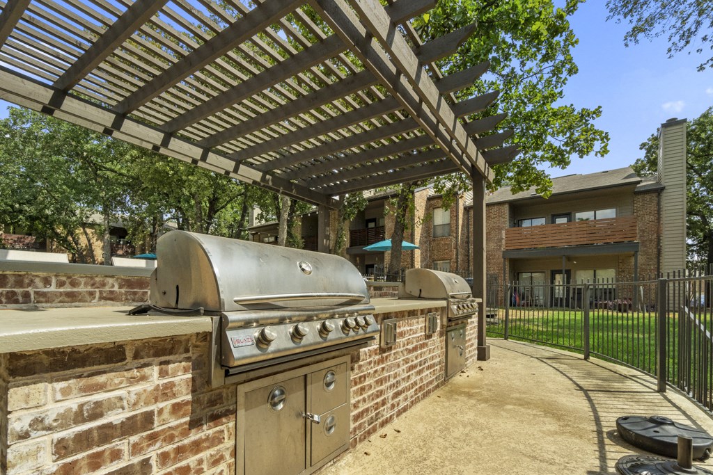 a patio with a barbecue grill and a pergola