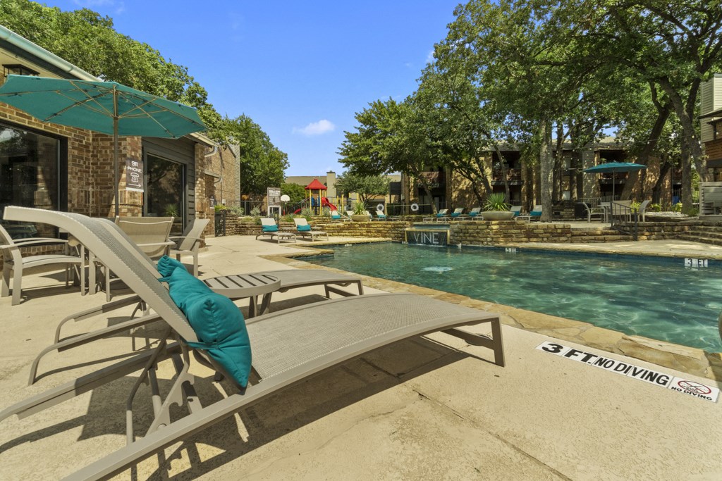 a pool with chairs and umbrellas next to a swimming pool