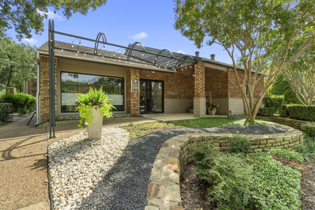 a backyard with a house with a patio and a gravel pathway