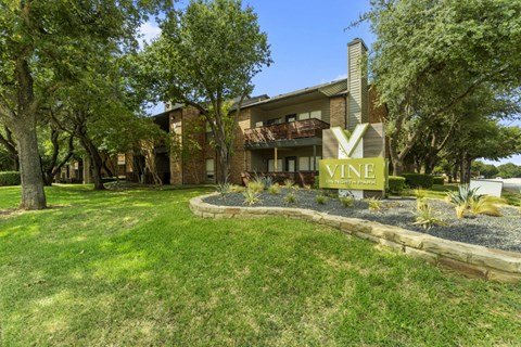 a yard with a vineyard sign in front of a house
