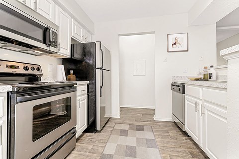 a kitchen with stainless steel appliances and white cabinets