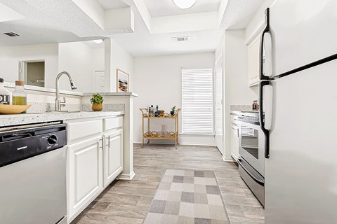 a renovated kitchen with white cabinets and stainless steel appliances
