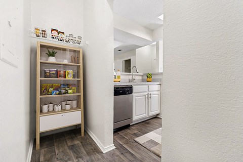 a kitchen with white cabinets and a shelf with spices