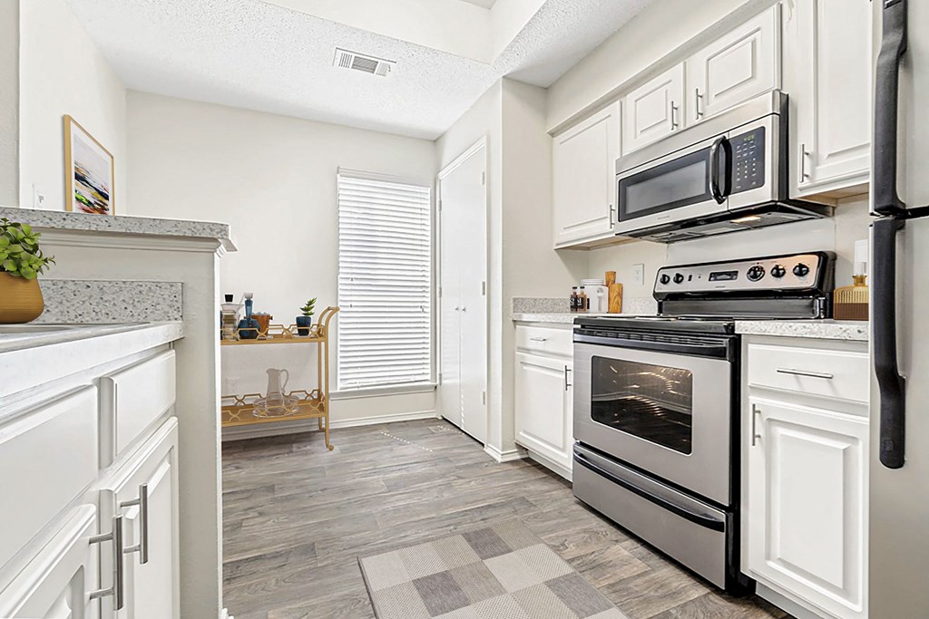 a renovated kitchen with white cabinets and stainless steel appliances