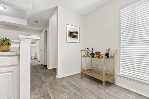 the living room and dining room of a home with white walls and wood floors