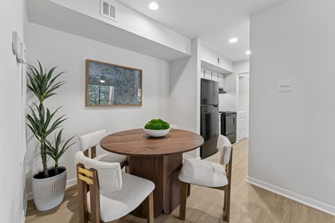 Dining area with round wood table and chairs at Knoll Crest Apartments, San Antonio, Texas