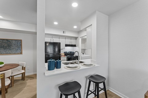 A kitchen with a table and two stools.