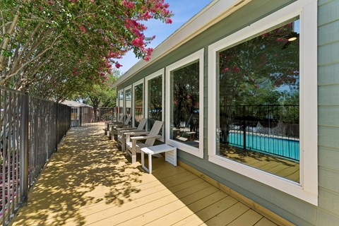 Covered outdoor deck with seating and pool view at Knoll Crest Apartments, Texas