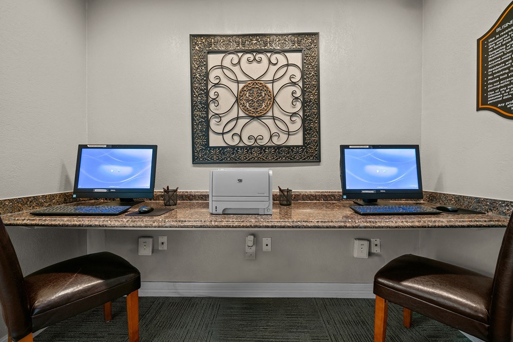a desk with three computers on it