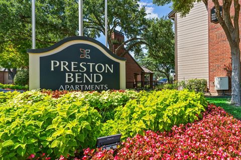 a sign for the presbyterian bend apartments with flowers in front of it
